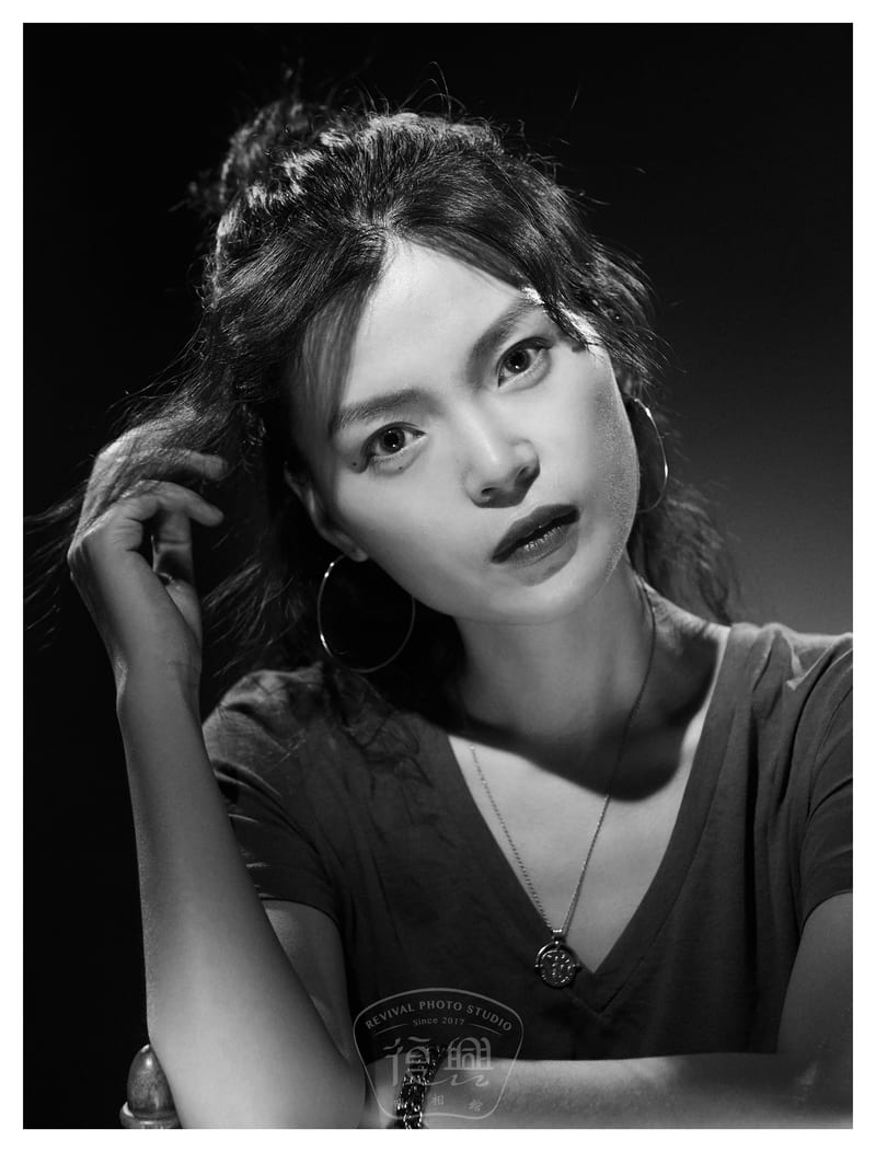 黑白肖像：女性侧头看向镜头，戴大耳环